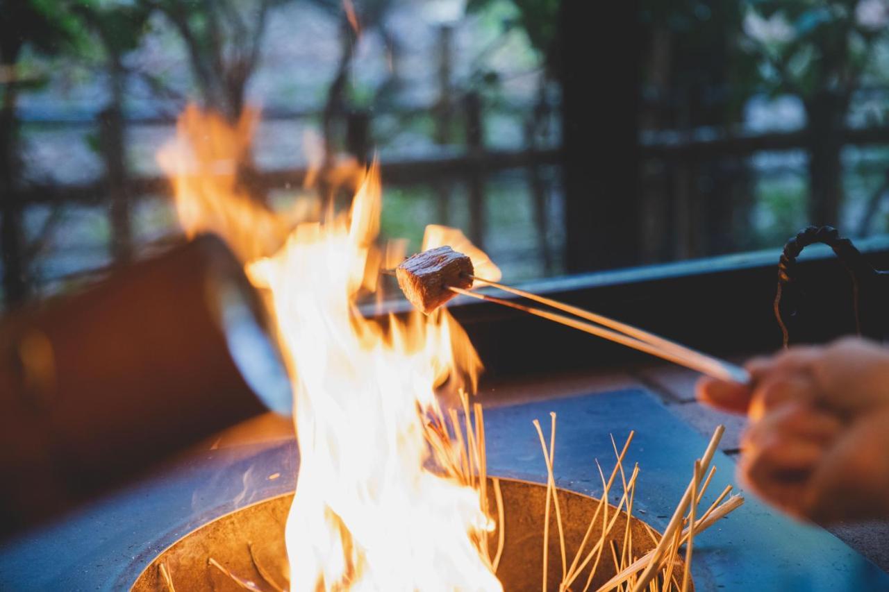 Arima Onsen Tocen Goshobo Kobe Exterior foto A piece of meat being cooked over a fire